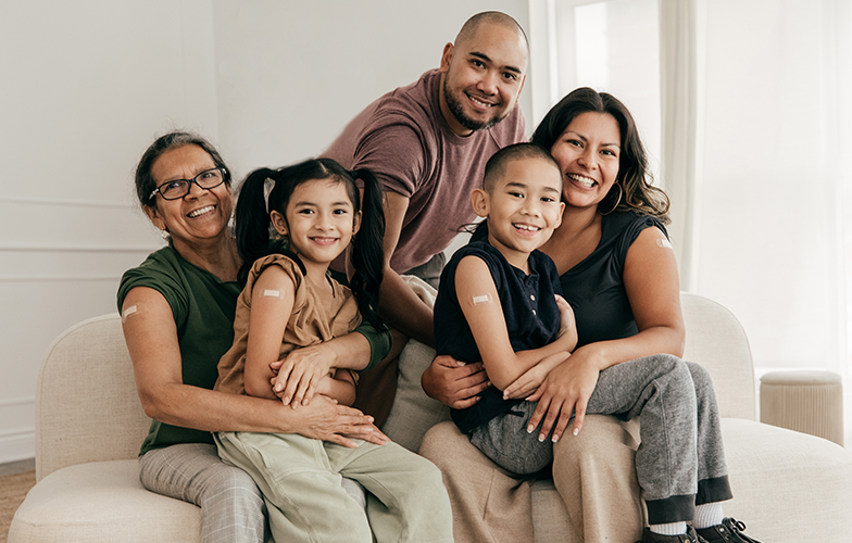 https://www.albertsons.com/content/dam/pharmacy/pharmacy-b2c-new/vaccines/happy-family-sitting-together-on-a-sofa-showing-vaccinated-spot-on-right-arm.png